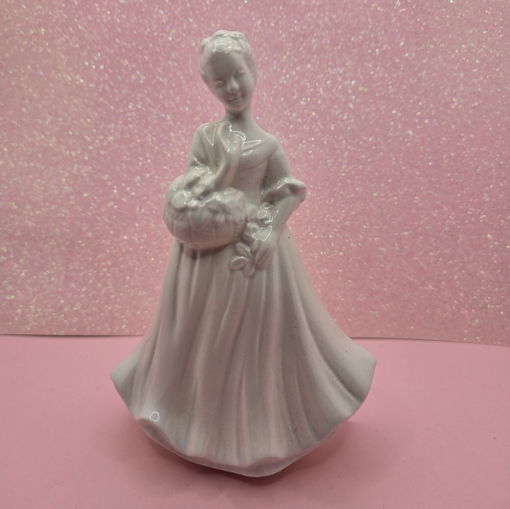 Vintage white figurine of woman holding flowers